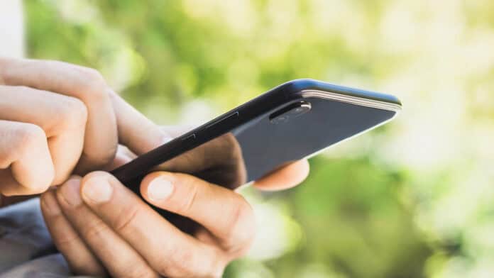 A person holding their phone, scrolling through information.