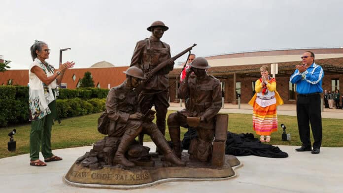 A new sculpture honoring the World War I Choctaw Code Talkers is dedicated today at the Choctaw Cultural Center. Unveiling the bronze are, from left, Nuchi Nashoba, President of the Choctaw Code Talkers Association; Assistant Chief Jack Austin Jr.; artist Jane Semple Umstead; and Chief Gary Batton